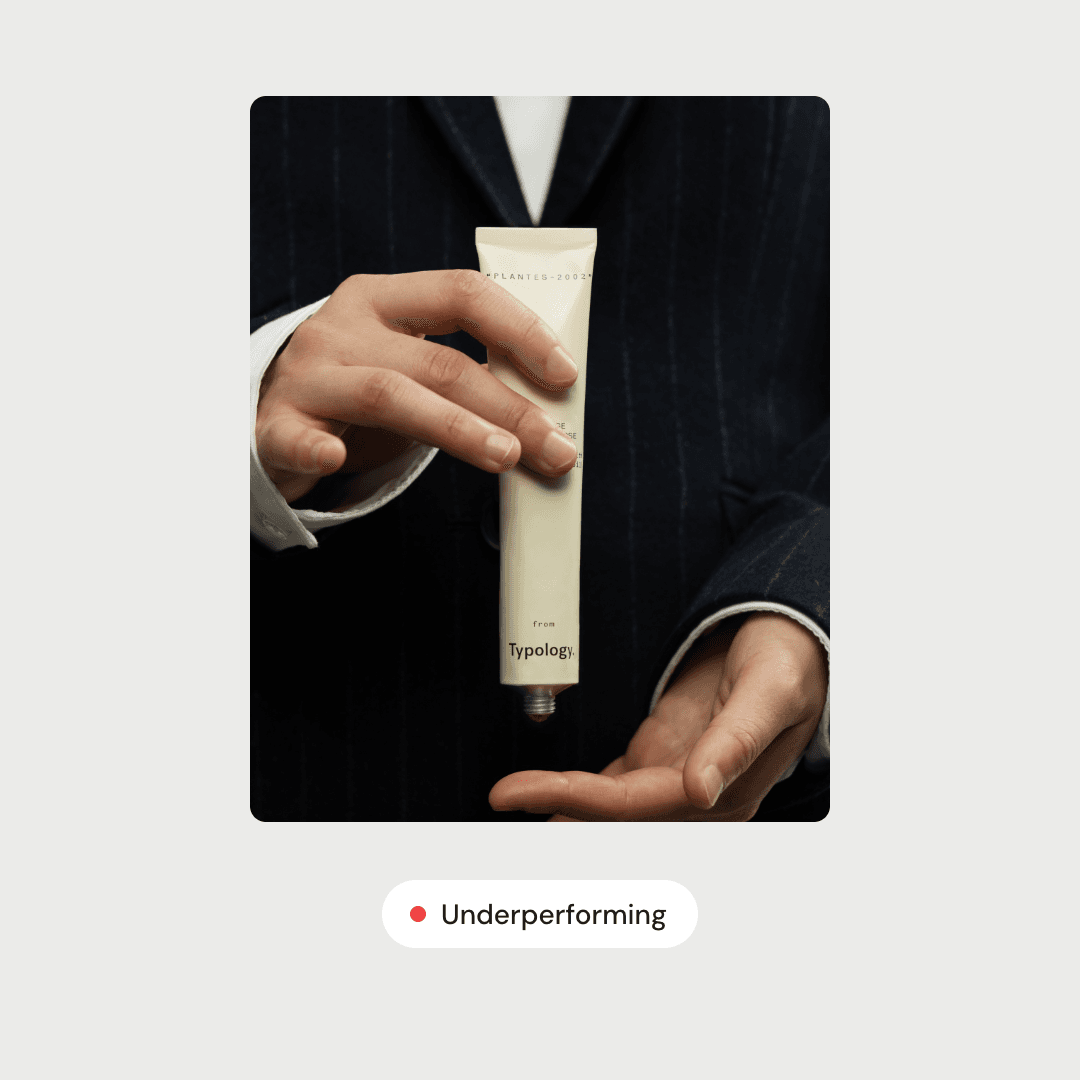 An ad showing hands holding a tube of skincare, tagged Underperforming.