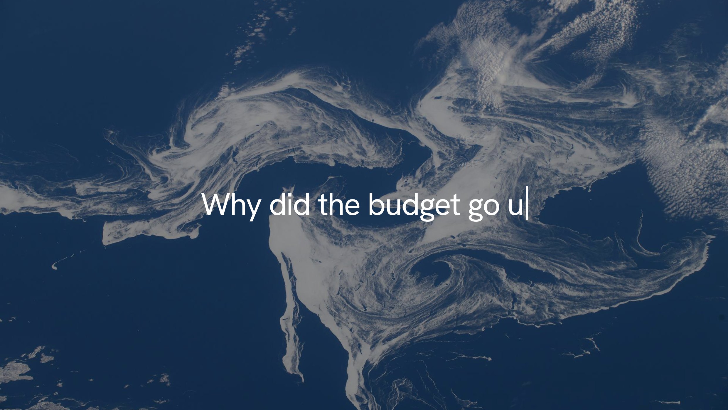 The question 'Why did the budget go up' being typed over a satellite view of sea ice.